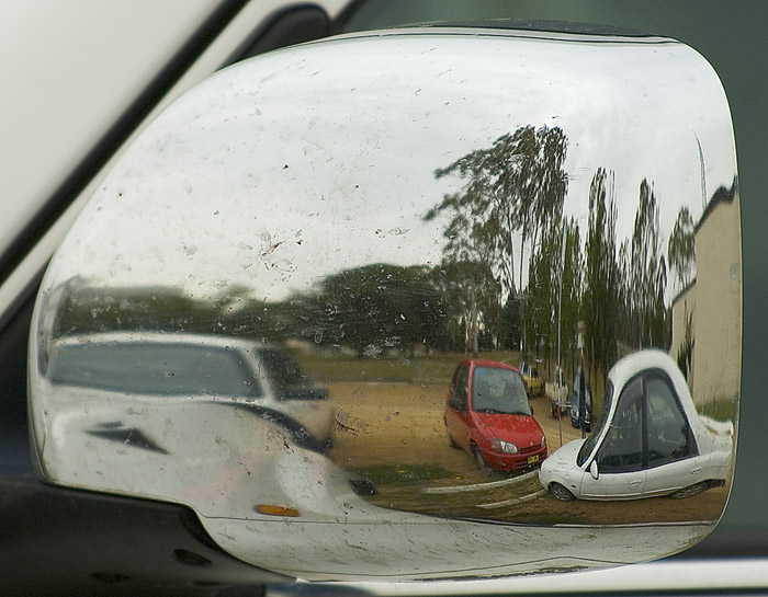 Parked cars reflected in a car wing mirror